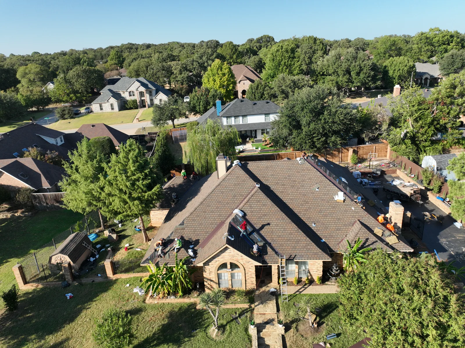 Aerial photograph of roofing work on a house with materials around the property